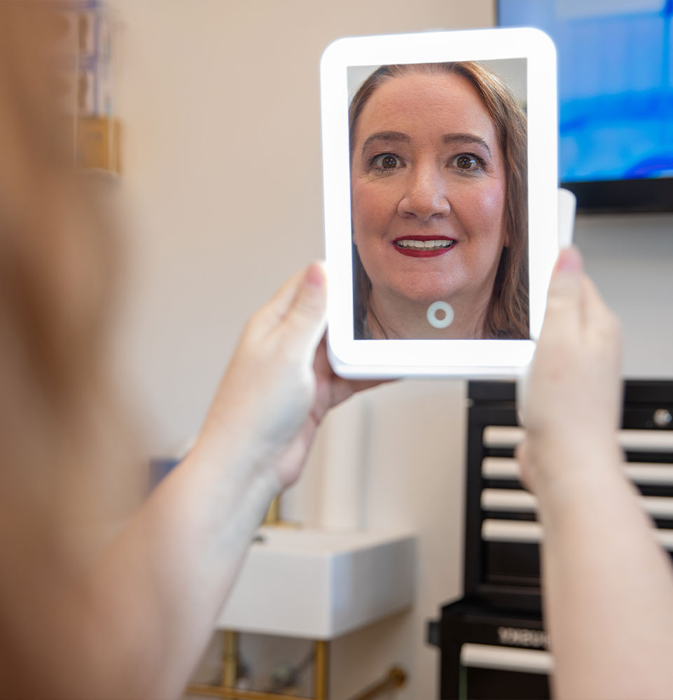 patient smiling into mirror after dental procedure