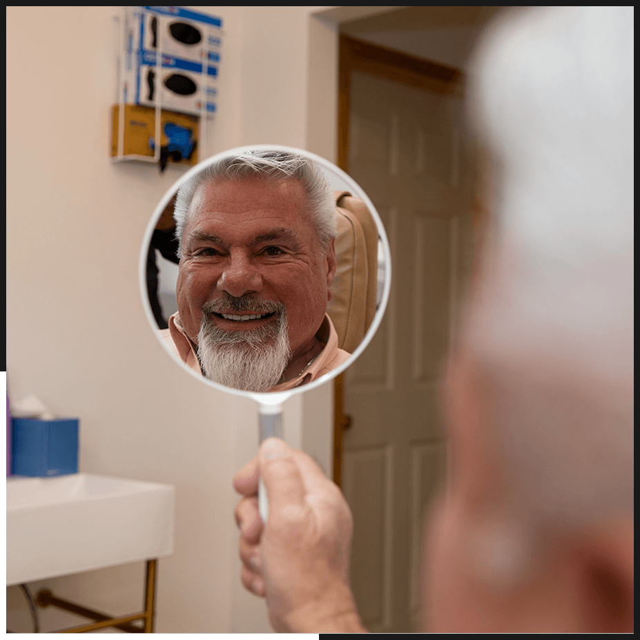 patient smiling into mirror