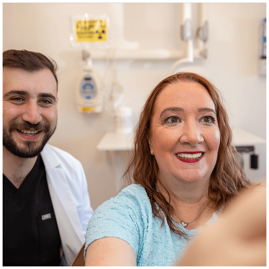 doctor and patient looking into mirror smiling