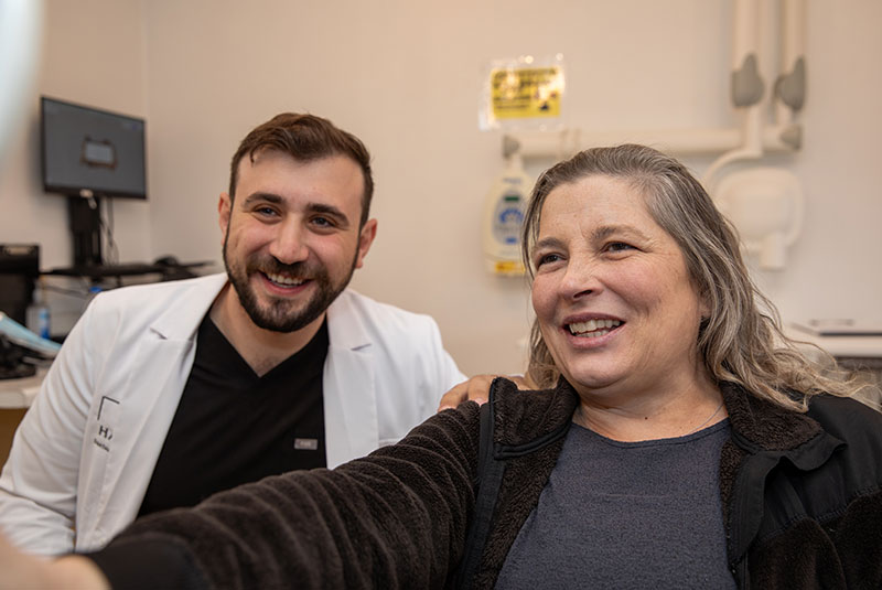 patient smiling into mirror