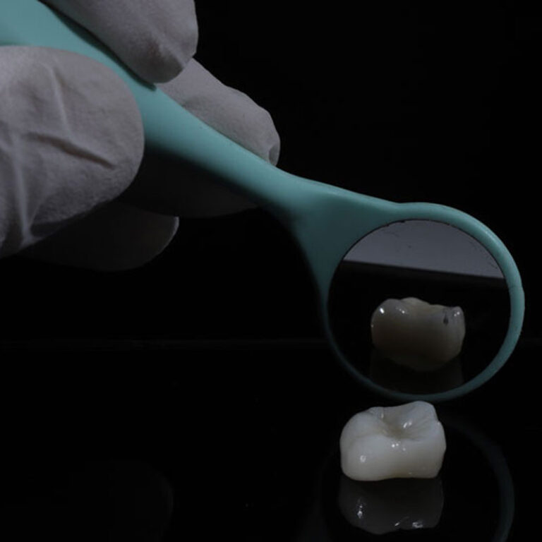 a dental crown being shown with a mirror behind it