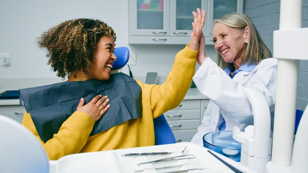 women smiling and speaking with a dentist in dental office